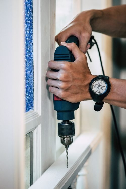 carpenter-holds-drill-drills-window_1150-24060